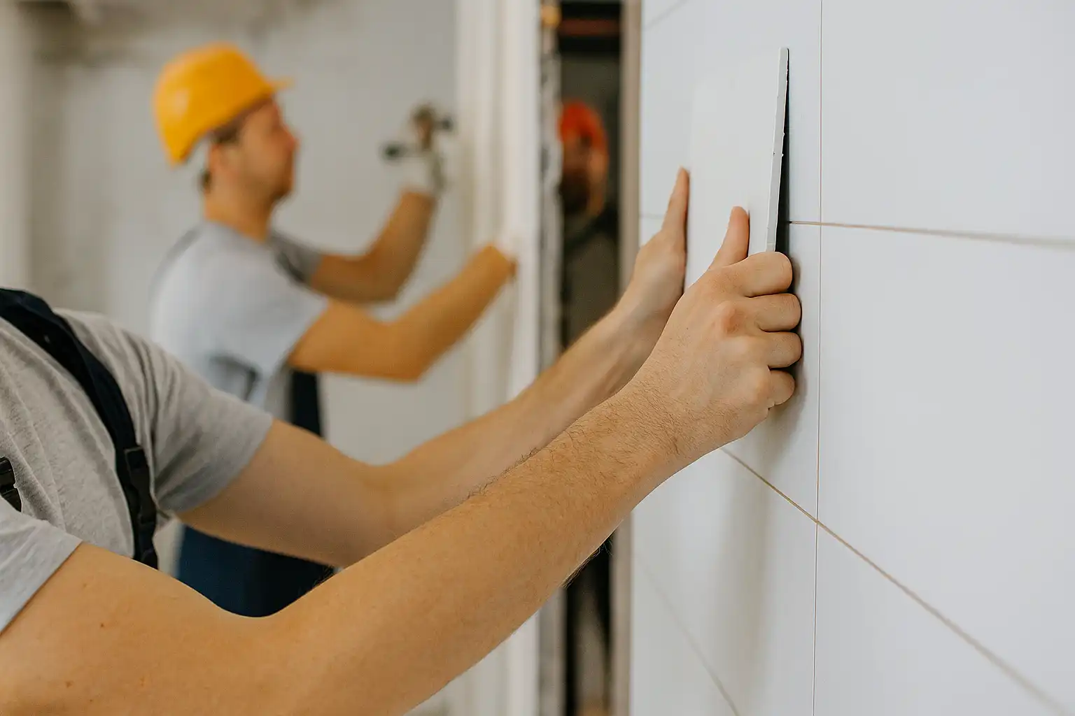 Home Fitting - Construction worker placing a ceramic wall tile during home interior work